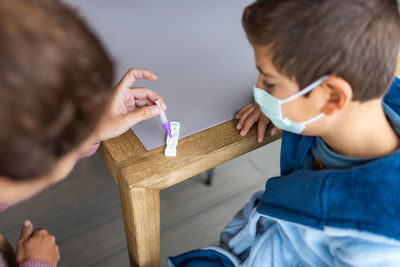 Mother doing an antigen test to her son at home