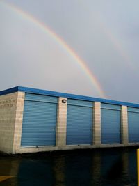 Rainbow over building against sky