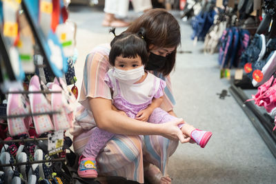 Rear view of mother and daughter at store