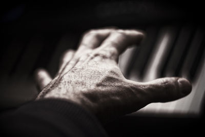 Cropped image of hand playing piano