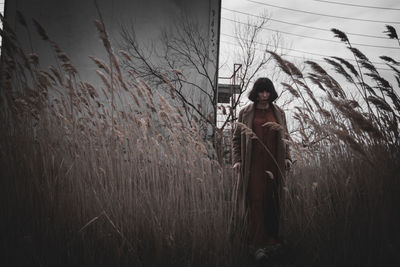 Woman standing on field against sky