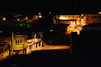 Illuminated town against sky at night