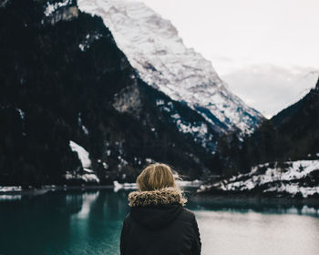 Rear view of woman standing on mountain against sky