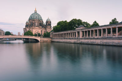 Arch bridge over river against buildings