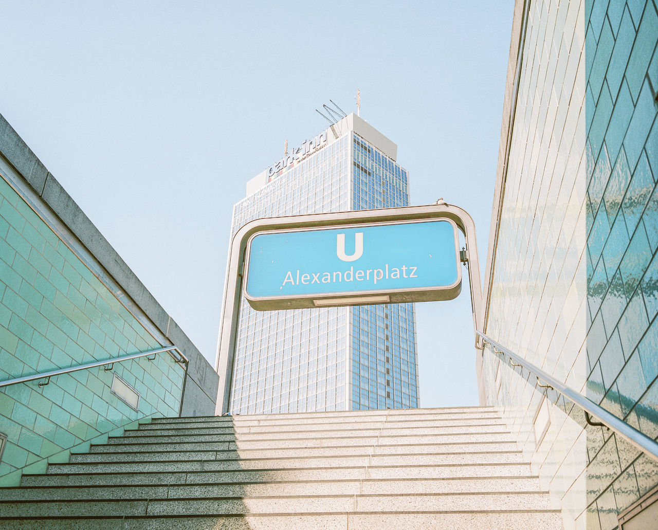 architecture, text, sign, communication, low angle view, built structure, western script, sky, guidance, direction, blue, no people, building exterior, day, clear sky, information, staircase, nature, script, arrow symbol, office building exterior