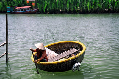 Person sitting in basket boat on river