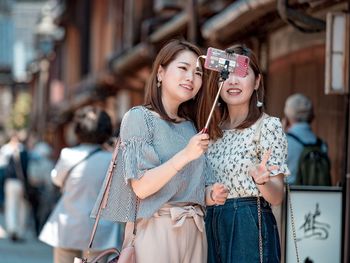 Portrait of smiling young woman using mobile phone