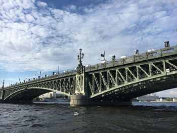 Bridge over river against cloudy sky