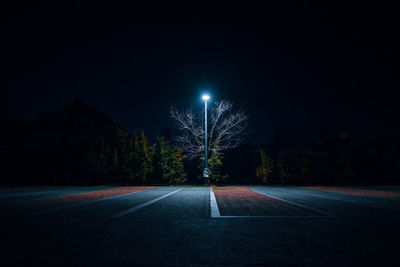 Illuminated street light on footpath at night