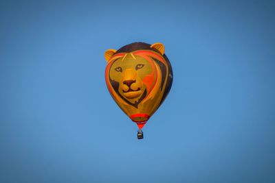 Low angle view of hot air balloon against clear blue sky