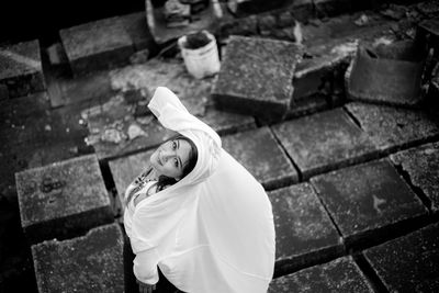 High angle portrait of young woman standing on footpath