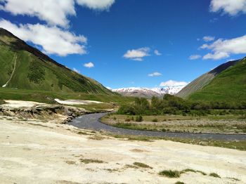 Scenic view of lake by mountains against sky