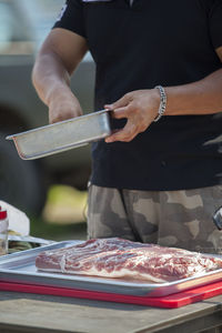 Midsection of man preparing food in container