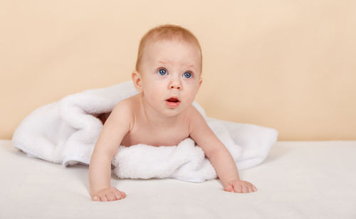 Boy looking away on bed at home