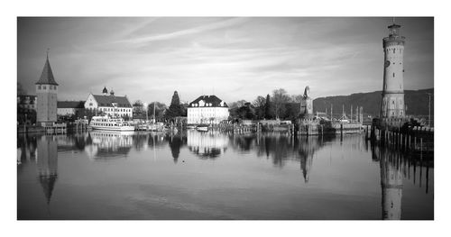 Buildings and lighthouse by river at lindau