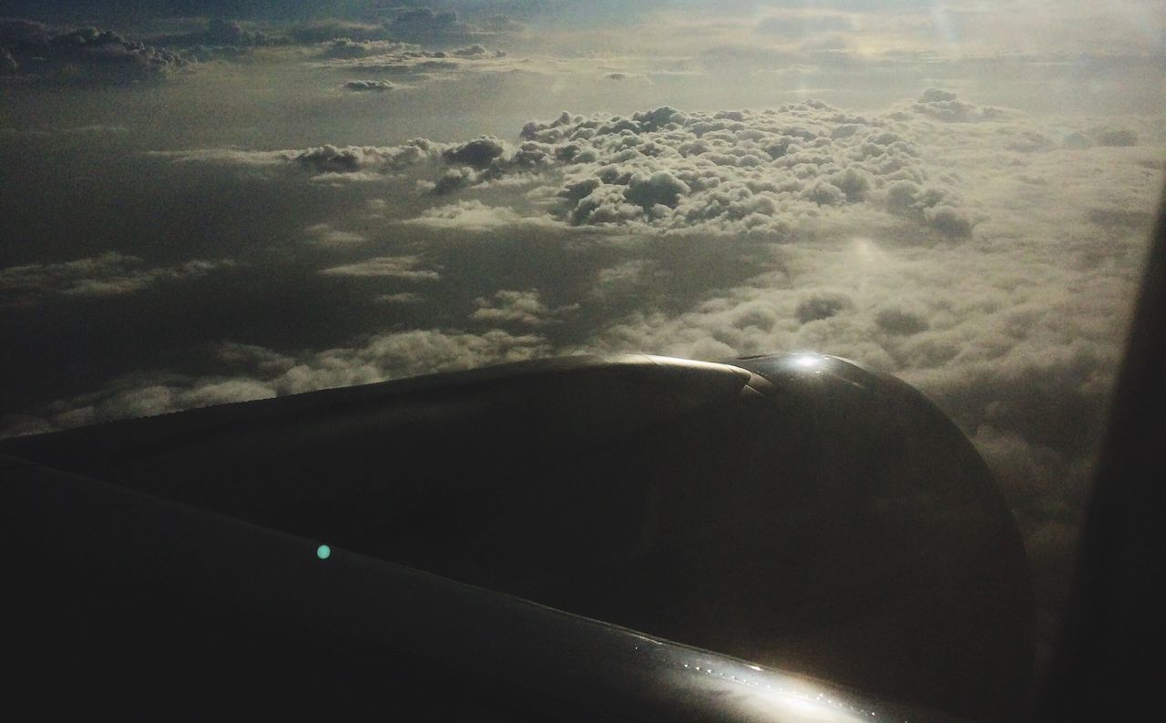 CROPPED IMAGE OF AIRPLANE FLYING OVER CLOUDS