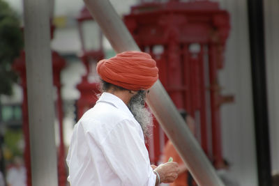 Side view of man wearing turban while standing outdoors