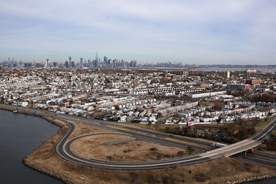 High angle view of road by buildings against sky