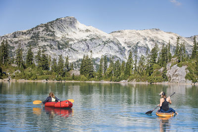 Mother and daughter enjoy boating on beautiful blue alpine lake