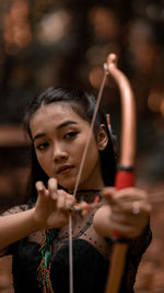 Portrait of woman shooting an arrow in the jungle