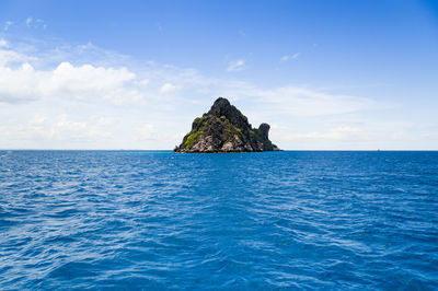 Scenic view of rock formation in sea against sky