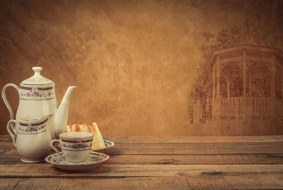 Close-up of tea cup on table against wall