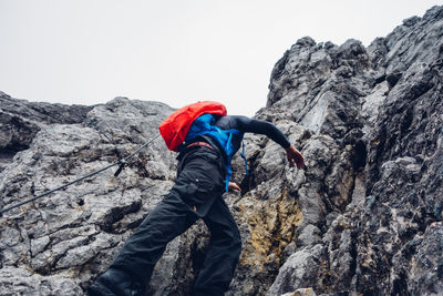 Rear view of man on cliff against mountain
