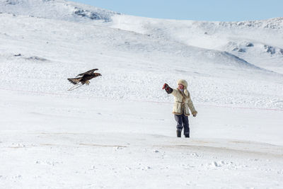 Woman and bird on snow