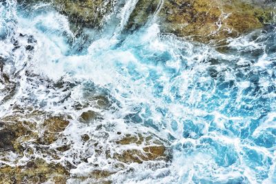 High angle view of waves splashing on rocks