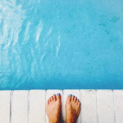 Low section of man standing in swimming pool