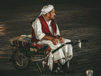 Midsection of man sitting at shore