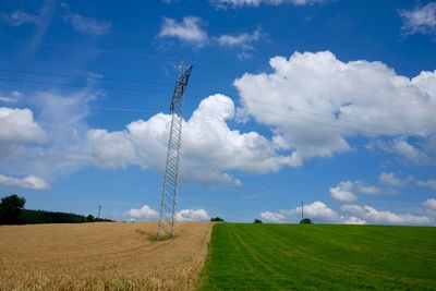 Electricity pylon on field against sky