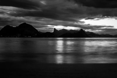 Scenic view of sea and mountains against sky