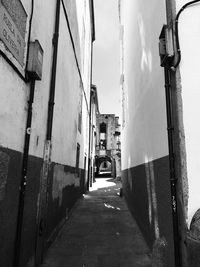 Alley amidst houses against sky