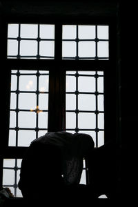 Portrait of man sitting in glass window