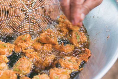 Close-up of person frying food in kitchen utensil