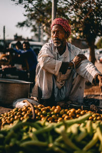 Midsection of man with vegetables at market stall