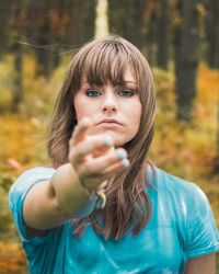 Close-up portrait of young woman standing in forest