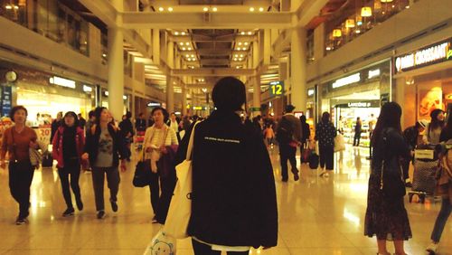 Group of people walking in illuminated corridor