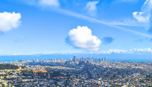 View of cityscape against cloudy sky