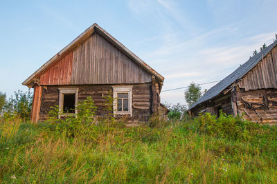 Abandoned house on field against sky