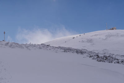 Scenic view of snowcapped mountains against blue sky