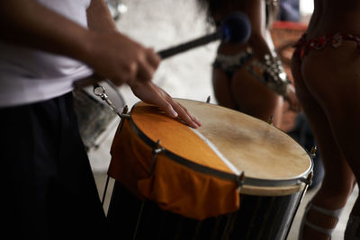 Midsection of man playing drum