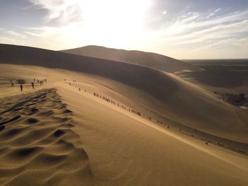 People at desert against sky