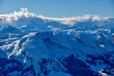 Aerial view of snowcapped mountains against sky