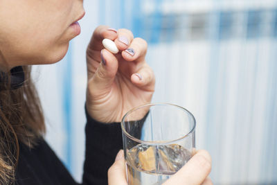 Midsection of woman holding wineglass