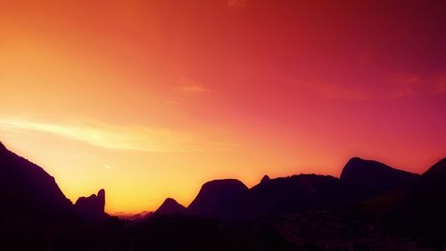 Scenic view of silhouette mountains at sunset