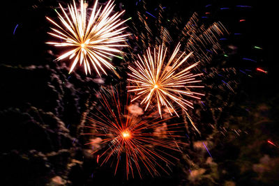 Low angle view of firework display at night