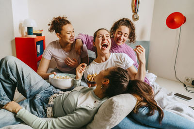 Female friends having fun and enjoying snacks at home