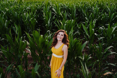 Portrait of smiling young woman standing in field